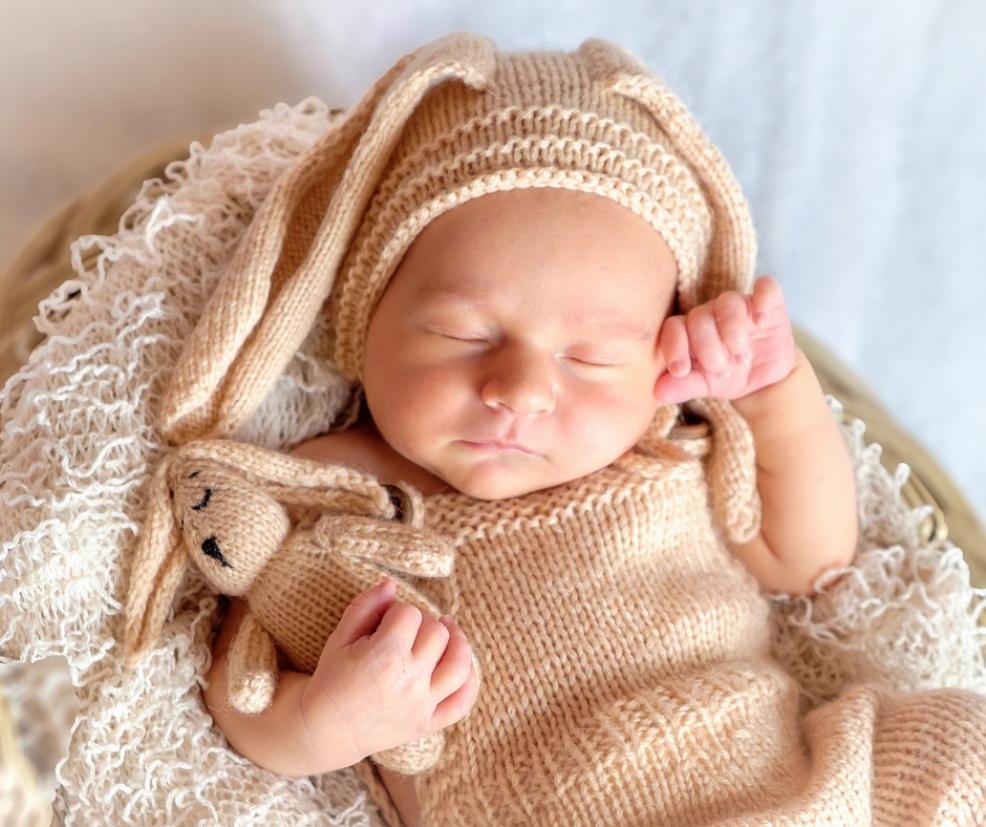 picture of a baby in woollen outfit with cuddly toy