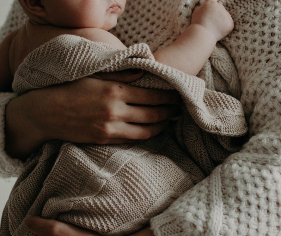 picture of a baby wrapped in a neutral woollen blanket