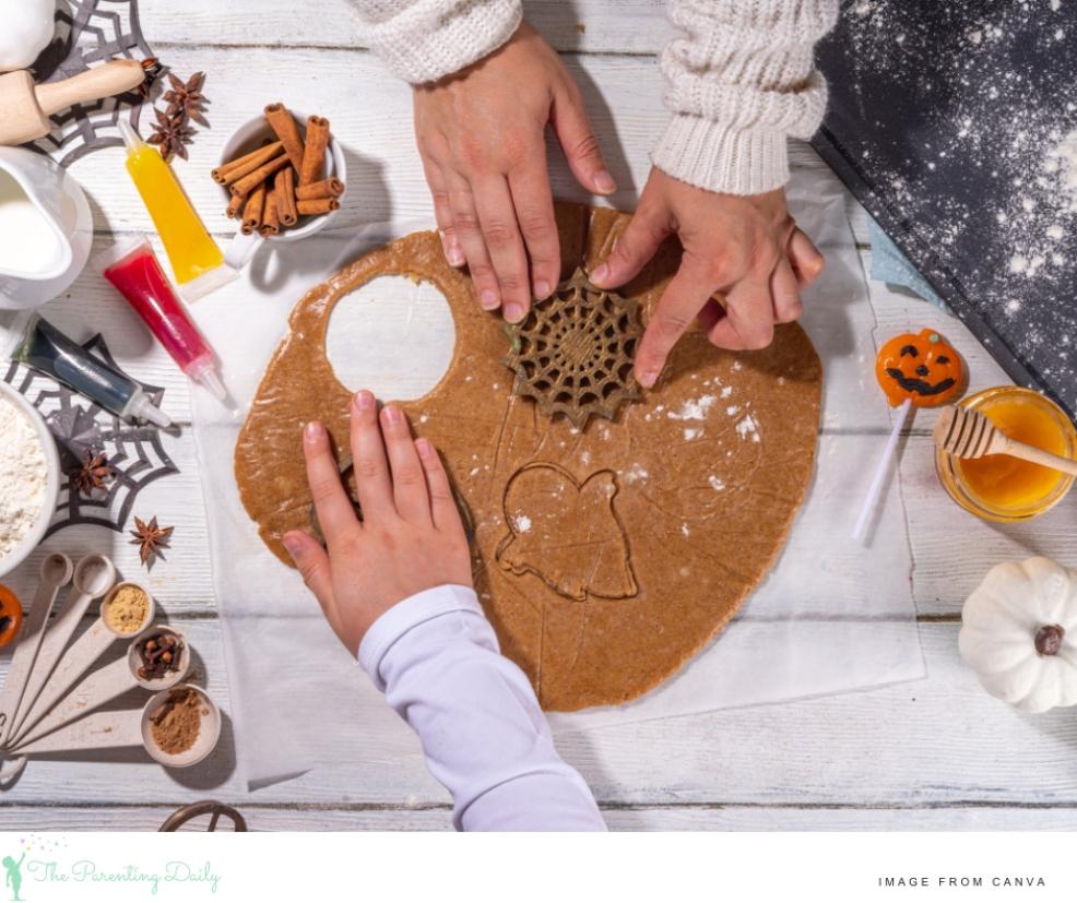 rolled out biscuit mixture being cut with halloween themed cookie cutters picture of rolled out biscuit mixture being cut with halloween themed cookie cutters
