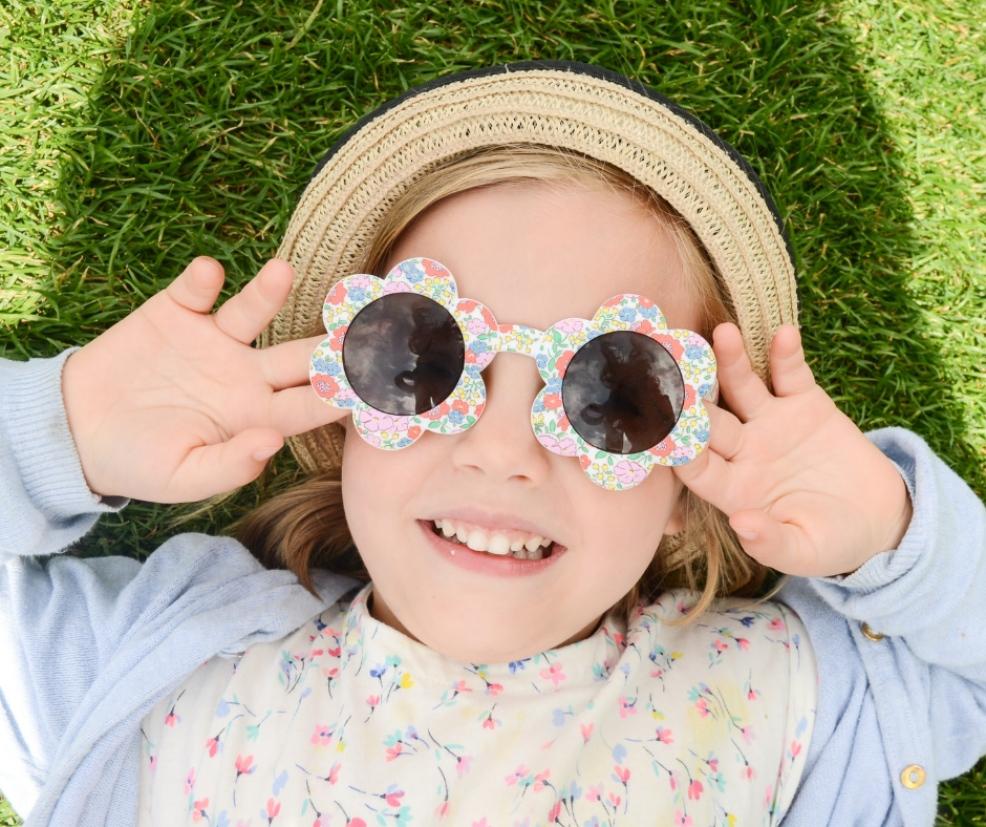picture of a child wearing sunglasses and a hat in the sunshine