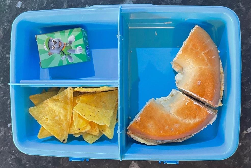 picture of a childrens lunchbox with bagel raisins and tortilla chips