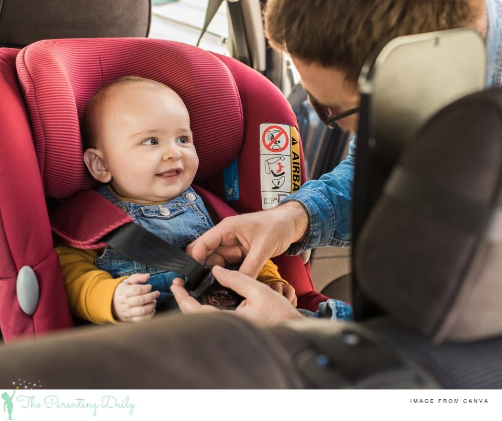 picture of a dad putting baby in a rear facing car seat