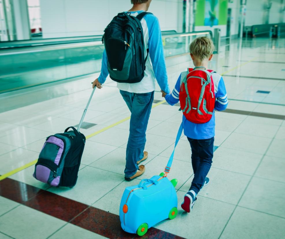 picture of a dad walking through airport with son and fun luggage