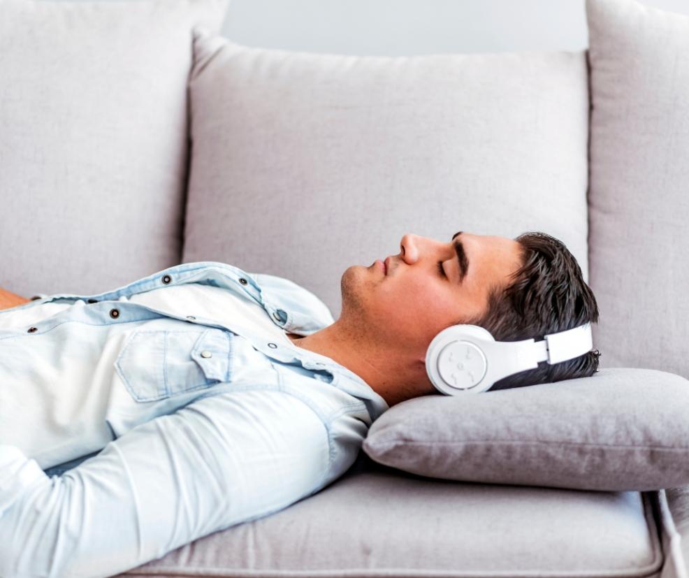 picture of a man relaxing on a sofa wearing headphones