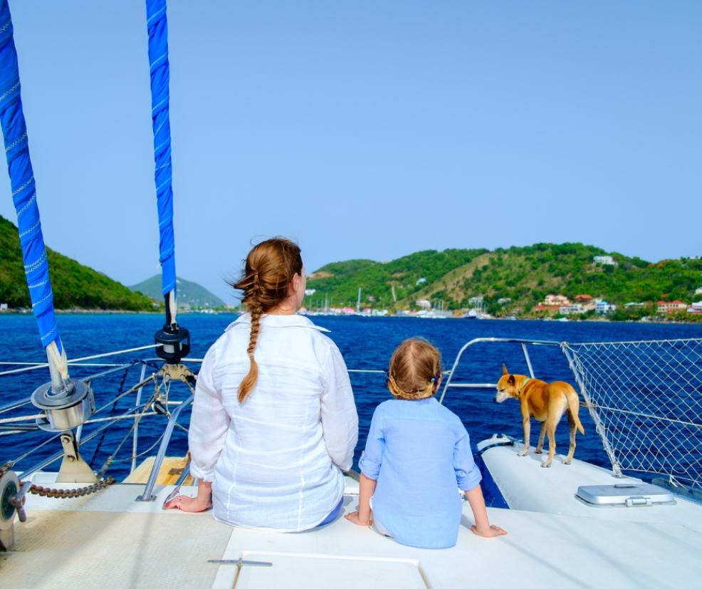picture of a mum and child on a sail boat with their dog