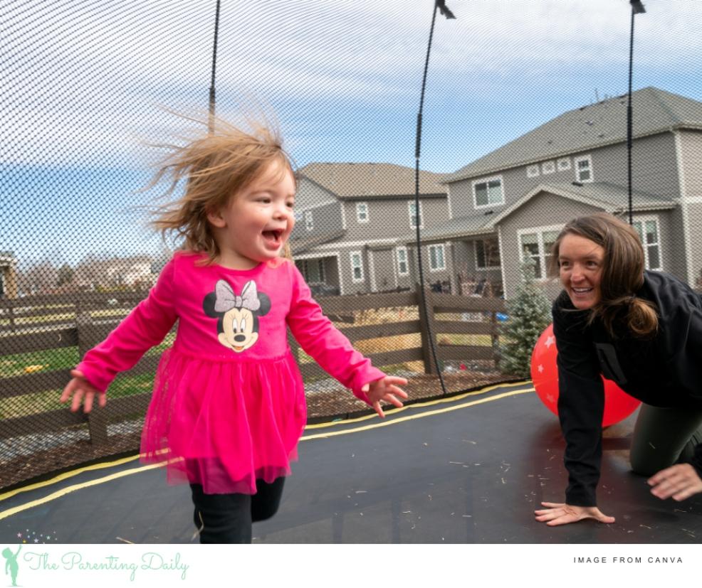 mum and child playing on a trampoline picture of a mum and child playing on a trampoline
