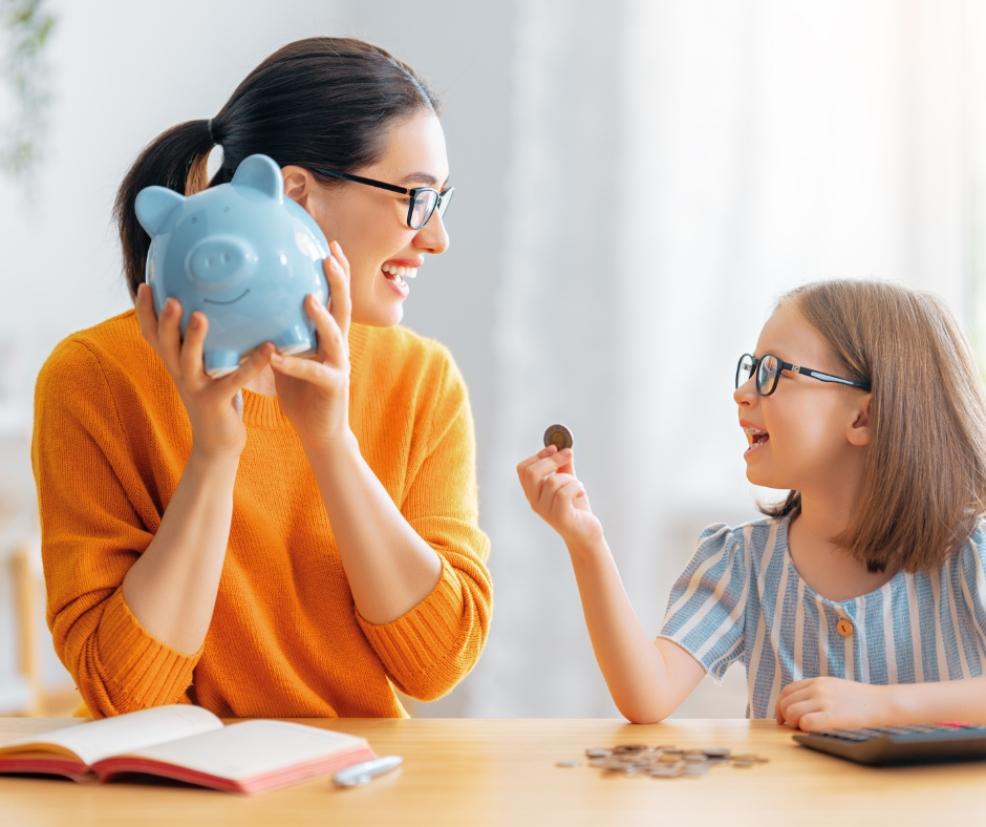 picture of a mum and daughter putting money in a piggy bank