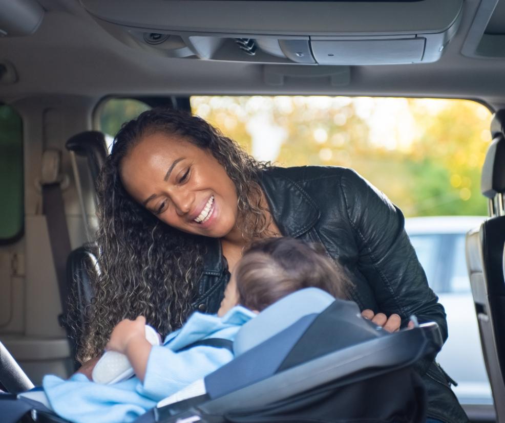 picture of a mum putting a baby into a car