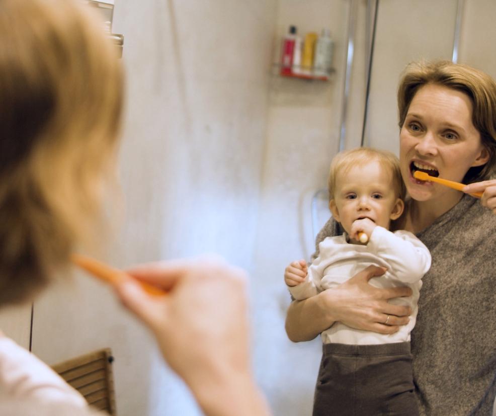 picture of a parent teaching a child how to brush their teeth
