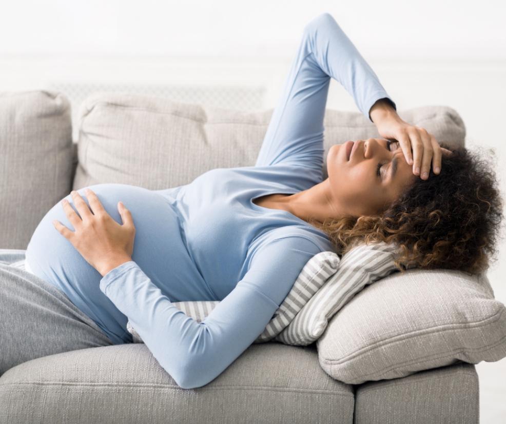 picture of a pregnant woman holding her head and bump