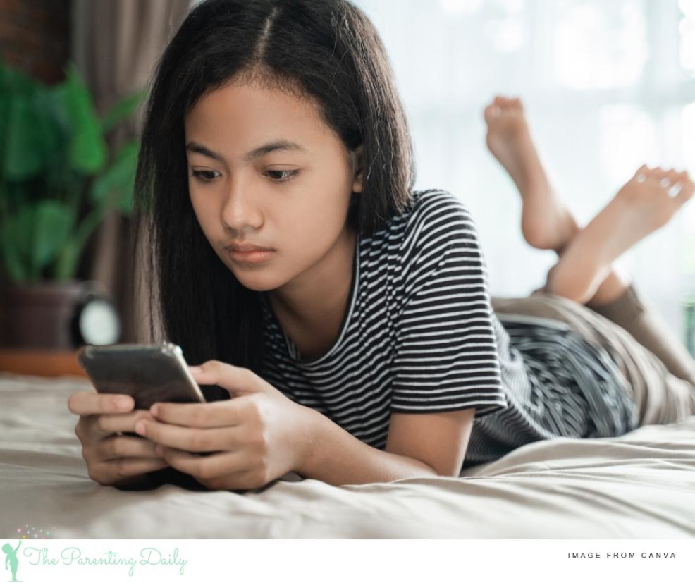 picture of teen on a smartphone laying on her bed