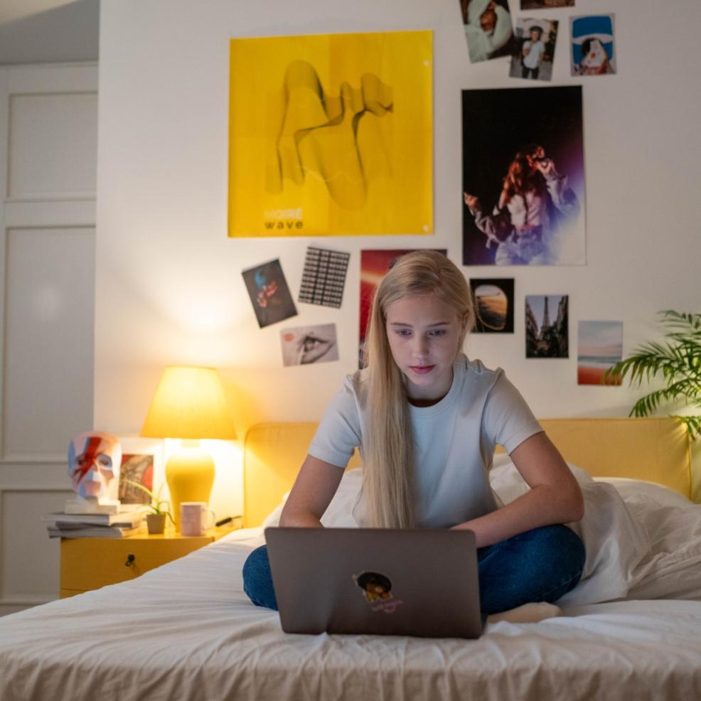 picture of a teen on her computer in bed