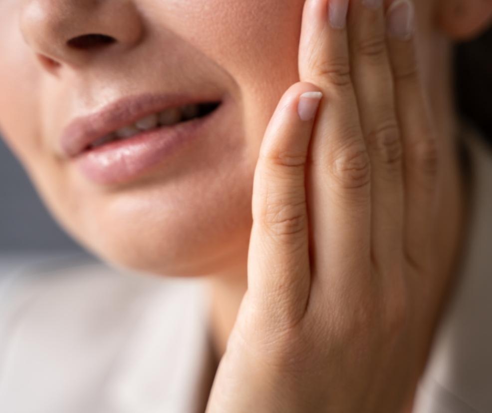 picture of a woman holding her mouth in pain