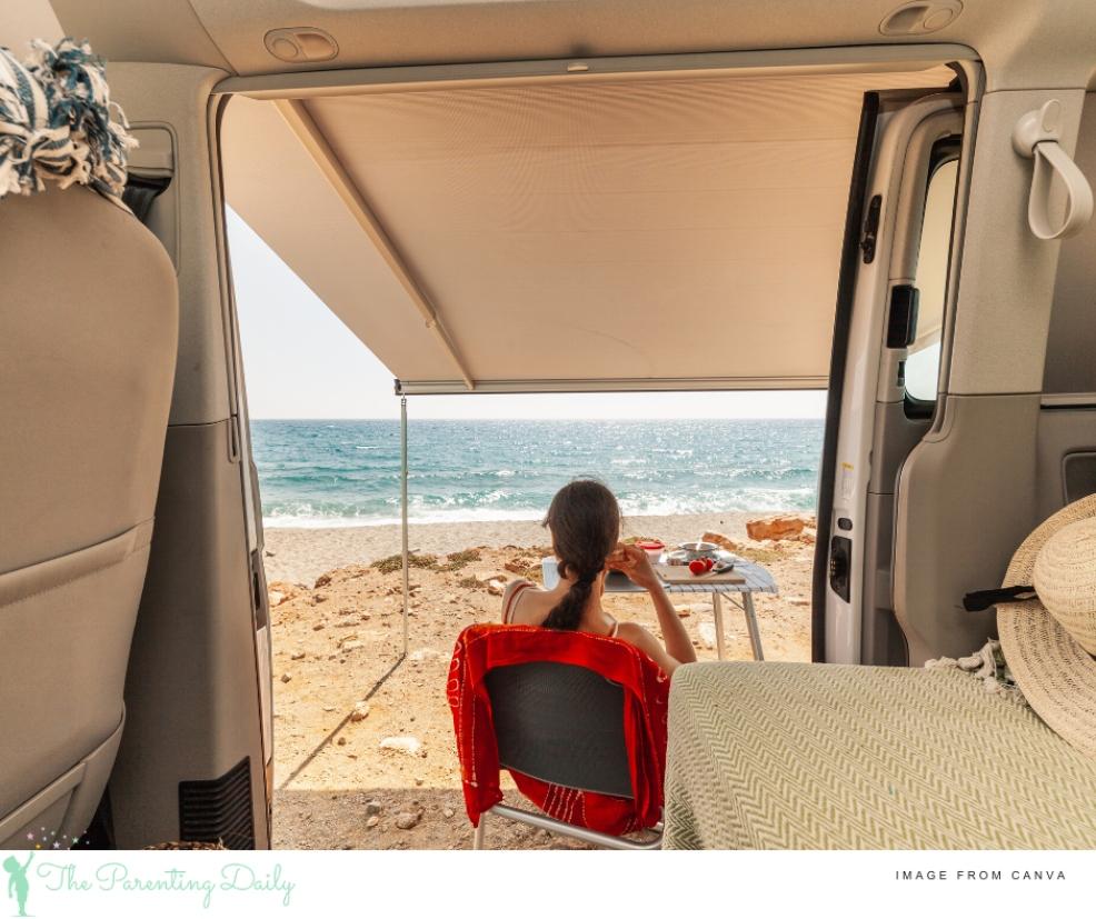 picture of a woman sat outside a caravan with a sunny beach scene