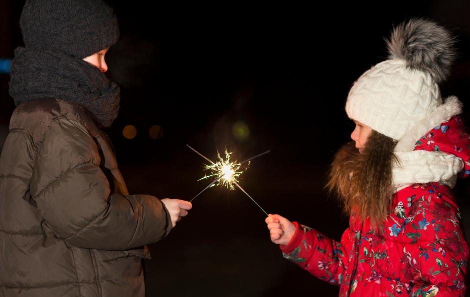 picture of boy and girl children holding sparklers outside