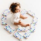 a baby sat on the floor surrounded by Mo and Marine baby wipes picture of a baby sat on the floor surrounded by Mo and Marine baby wipes