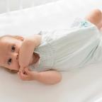 picture of a happy baby laying on a Hippychick fitted bedsheet