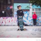 a child with a skateboard and helmet at a skatepark picture of a child with a skateboard and helmet at a skatepark