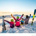 a family on a ski holiday sitting in the snow looking at the sun set picture of a family on a ski holiday sitting in the snow looking at the sun set