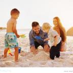 picture of a happy family on a beach building a sandcastle whilst on holiday