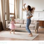picture of a happy healthy mum dancing with her daughter in the living room