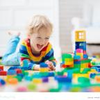 a happy toddler playing with lots of colourful building blocks picture of a happy toddler playing with lots of colourful building blocks