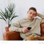 picture of a teenage boy who is looking at Youtube mental health shelves on his smart phone