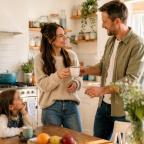 picture of Couple sharing a cup of tea in a bright family kitchen while child watches, showing everyday love and kindness at home