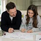 Dad helping his teenage daughter create a revision timetable at a kitchen island in a bright family home picture of Dad helping his teenage daughter create a revision timetable at a kitchen island in a bright family home