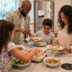 Family eating together at home showing the importance of shared mealtimes and family picture of Family eating together at home showing the importance of shared mealtimes and family