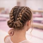 picture of a tween gymnastic with dutch hair braids into a bun for gymnastic competition hair