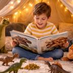 picture of young boy reading a dinosaur book inside a cosy play tent with fairy lights, surrounded by toy dinosaurs and exploring his curiosity through play