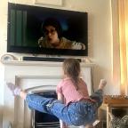picture of a child doing gymnastics moves on handstand blocks in front of the tv
