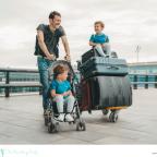 picture of a dad at an airport with his two children and lots of suitcases moving abroad