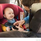 a happy baby being strapped into a car seat in a car by their parent picture of a happy baby being strapped into a car seat in a car by their parent