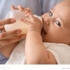 picture of a happy baby drinking a bottle of milk that has been prepared quickly