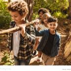 picture of happy children carrying a branch whilst at a nature childrens camp