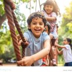 picture of happy resilient children playing on a rope bridge together in a park