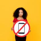 picture of a child holding a sign saying mobile phones are banned