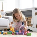 Little cute girl playing block toys in playroom at home