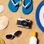 picture of holiday essentials on a sandy beach