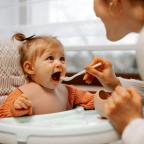 woman feeding a baby with a spoon