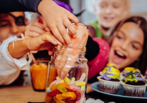 picture of a happy family digging into a sweet jar at Halloween