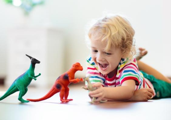a happy toddler playing with dinosaurs and practising animal sounds picture of a happy toddler playing with dinosaurs and practising animal sounds