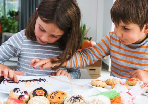 image of two children baking some autumn themed cookies as a screen free activity idea