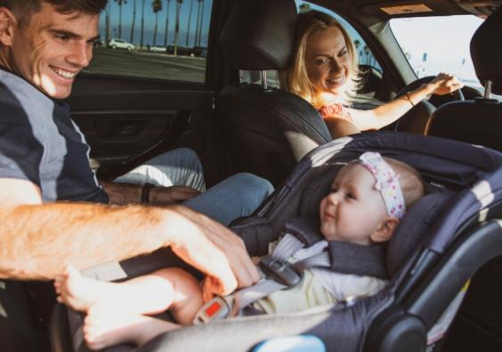 picture of a baby in a rear facing car seat with mum and dad