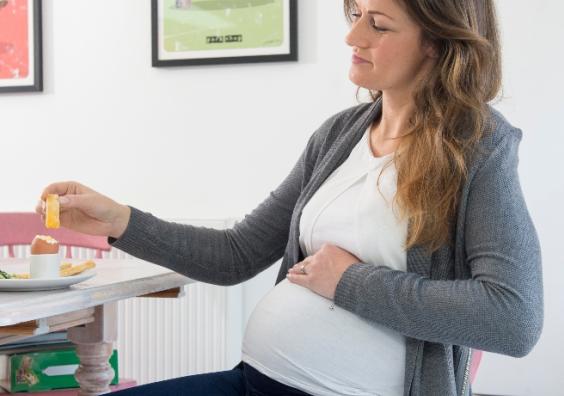 picture of a pregnant woman eating British Lion boiled eggs to aid healthy brain