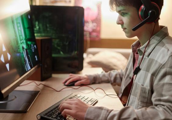 picture of a boy online gaming on a desktop computer in his bedroom