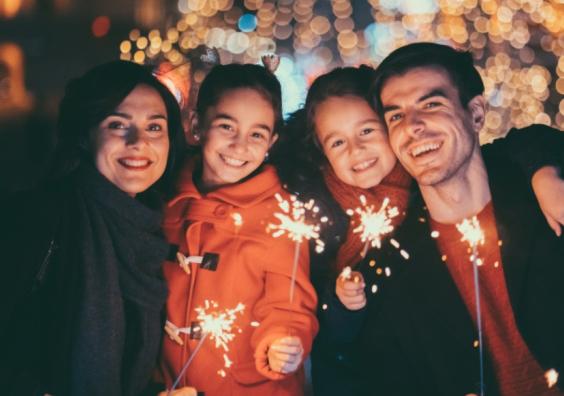 picture of a happy family holding sparklers celebrating New Years Eve together