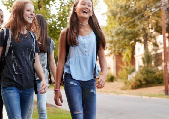 happy teenagers walking down the street thinking about their futures picture of happy teenagers walking down the street thinking about their futures